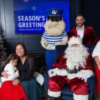 Parents with three daughters smiles with Santa and Louie